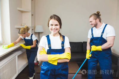 在工作過程中使用專業設備的清潔服務。專業的小廚房清潔, 沙發干洗, 窗戶和地板清洗。穿制服、工作服和橡膠手套的男人和女人